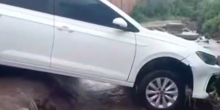 Carro é levado por enxurrada e fica preso em vala durante chuva no DF
