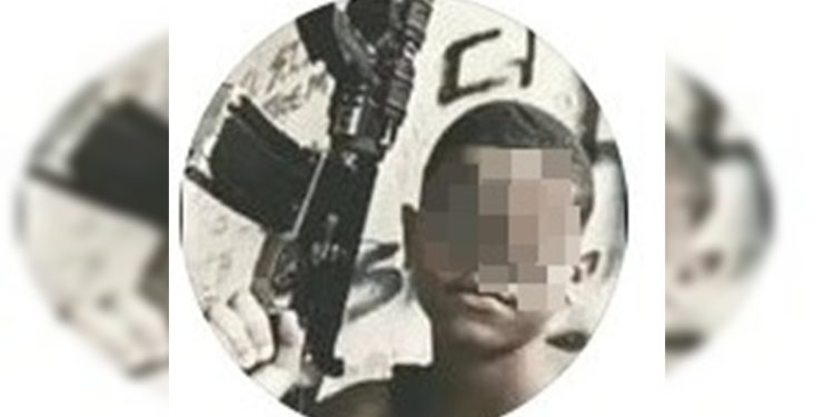 “Dedão” para a PM: adolescente agredido posa com fuzil e fumando