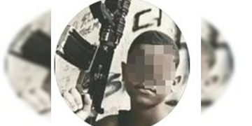 “Dedão” para a PM: adolescente agredido posa com fuzil e fumando