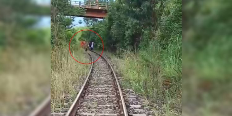 Homem cai de ponte, vai parar nos trilhos e escapa de trem por minutos. Veja vídeo